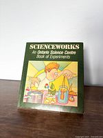 Front cover of the Scienceworks vintage experiment book showing cartoon illustration of a child doing science experiments.