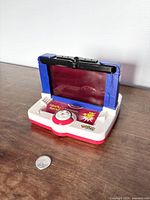 Front view of the vintage Pokemon Battle Arena handheld game with foldable red translucent screen upright, buttons and controls visible on base.