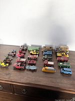 Image showing 21 vintage Tootsie Toys diecast vehicles including cars, trucks, motorcycles, camper units, and trailers in multiple colors with wear.