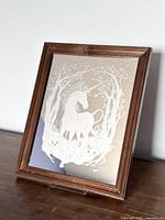 Front view of the vintage mirror showing the etched unicorn design and wooden frame.