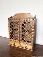 Front view of the vintage wooden spice rack showing lattice doors and two drawers at the bottom.