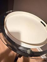 Top view of cream round wooden tray on glass table