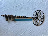 Full view of 29 in metal key wall decor placed beside ruler