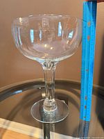 Full view of oversized stemmed glass beside ruler showing ~11 in height