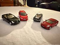All four die-cast toy cars on table