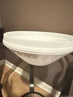 Side view of white milk glass bowl showing laurel leaf embossing