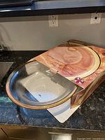 Top angle view of the decorative bowl in original packaging showing the gold rim and translucent interior bowl