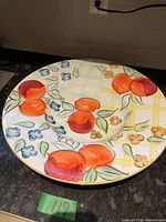 Top view of the large round ceramic centrepiece bowl showing the vivid fruit and flower design.