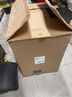 Closed cardboard box for Feiss chandelier with visible label stating model F2980/9SN, 9-light chandelier, uses 9 medium A19 75W bulbs, brushed nickel finish illustration shown.