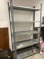 Front view of industrial steel shelving unit showing all shelves and steel frame.