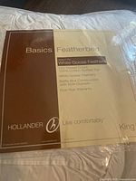 Close-up photo of the feather bed packaging detailing the product features and brand