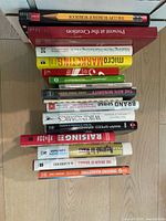 Top view of a stack of 15 hardcover and paperback marketing and branding books showing titles related to niche marketing, branding theories, market research, and the evolution of major brands.