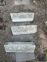 Top view of three rectangular concrete planters with detailed flower motifs on surface.