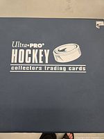 Blue Ultra PRO hockey card binder cover with logo and text 'Ultra PRO Hockey collectors trading cards'.