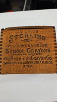 Front panel of wooden crayon box stamped with product information and manufacturer details.