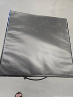 Closed black binder with textured surface, showing some wear and marks.