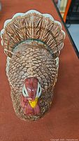Top view of ceramic turkey gravy boat showing detailed sculpted and painted feathers and head.