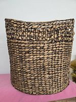 Front view of large woven wicker basket showing woven texture and natural brown color.