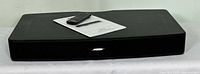 Front view of Bose Solo TV Sound System speaker with remote and operating guide on top.