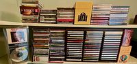 Full view of CD collection on shelves showing varied titles and organized stacks.