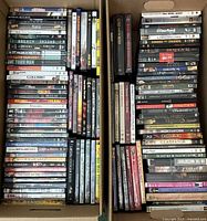 Two cardboard boxes side by side filled with DVD and Blu-ray cases showing full lot.