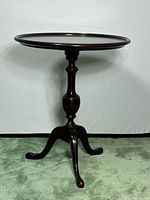 Full side view of the solid mahogany round side table showing the turned pedestal and tripod base with curved legs.