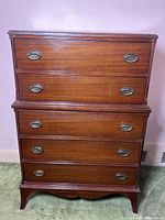 Front view of Gibbard tallboy dresser with five closed drawers showing oval metal handles and wood finish.