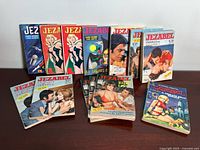 Selection of 12 Jezabel French comic books arranged standing and lying flat showing front covers with diverse illustrated scenes mainly of romance and drama.