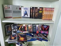 Shelf with Star Trek DVD box sets and individual DVD cases arranged, including seasons and movies.