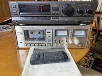 Front view of stacked Technics SA-GX130 receiver and Sony TC-K5 cassette deck with remote