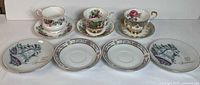 All three teacups with matching saucers and four additional saucers displayed, showcasing the variety of floral and decorative patterns.