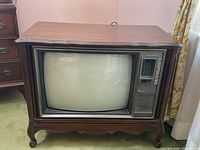 Front view of vintage Electrohome TV in mahogany cabinet, showing curved CRT screen, control panel, speaker grille, and wood cabinet detailing.