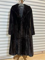 Front view of full-length mink coat hanging on hanger