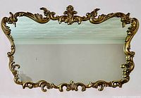 Full front view of mirror showing rectangular shape and ornate gold finish frame