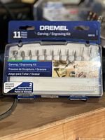 Blue plastic case with 11-piece Dremel Carving/Engraving Kit including 2 diamond points, front view.