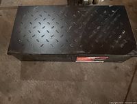 Closed large metal tool box with diamond plate lid, seen from above