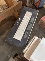 Box of white rectangular wall tiles on the floor showing packaging design and tile shape.