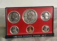 Front view of the set showing six proof coins on red background inside display.