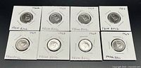 Eight 1967 Canadian nickels, uncirculated condition, secured in white cardboard holders with staples, labeled 'FROM ROLL'. Coins show bunny rabbit design commemorating Canada's centennial.