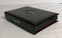Closed black leather-like display case with a silver maple leaf emblem and '1996' on the spine