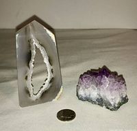 Front view of the amethyst geode and polished agate stone with a dime for size comparison.