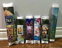 Collection of six rolled Diamond Art kits with printed images attached for identification.