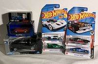 Seven collectible model cars, including five Hot Wheels cars in blister packs and two boxed collectible cars (BMW Z4 and Z3 models, plus a small blue Exactos car).