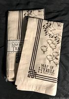 Two novelty tea towels folded and sealed in packaging showing Map of Hyrule design from The Legend of Zelda.