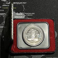 Photo of Canadian Silver Jubilee dollar coin in red velvet-lined display case with black plastic holder.