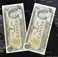 Two consecutive 1973 Canadian 1 Dollar banknotes depicting Queen Elizabeth II, front face shown in detail.