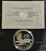 Photo of the coin with informational card about de Havilland Gipsy Moth flight history in Canada.