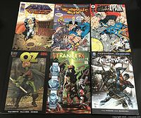 Six comic books laid out in two rows of three on a gray surface showcasing cover art and titles.
