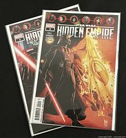Two comic books in protective plastic sleeves showing cover art of Star Wars Hidden Empire issues #2 and #3 with Darth Vader illustrations.