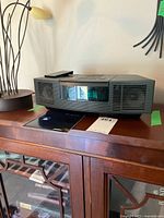 Front view of black Bose Wave Radio/CD showing digital display illuminated and speaker grilles.